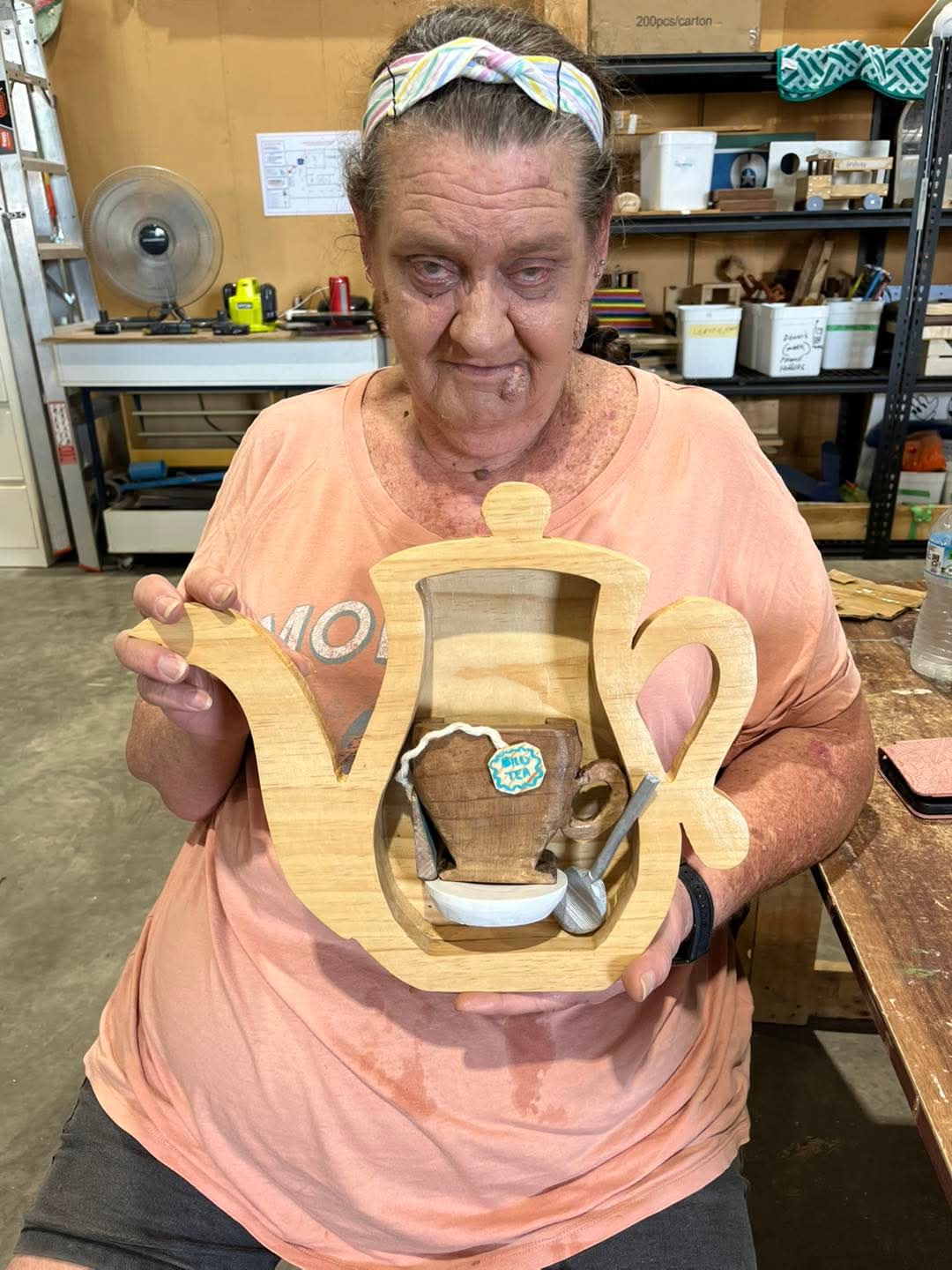 Participant holding a completed timber artwork
